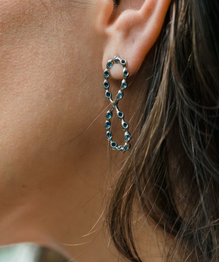 Elegant infinity heart earrings featuring blue gemstones, ideal for stylish, sophisticated looks.