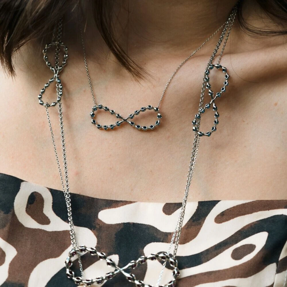 Elegant silver infinity pendant necklace with black accents for women.