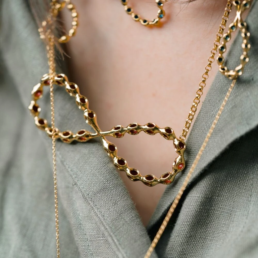 Elegant gold infinity pendant necklace with a modern design and intricate chain details. Perfect for stylish accessories.