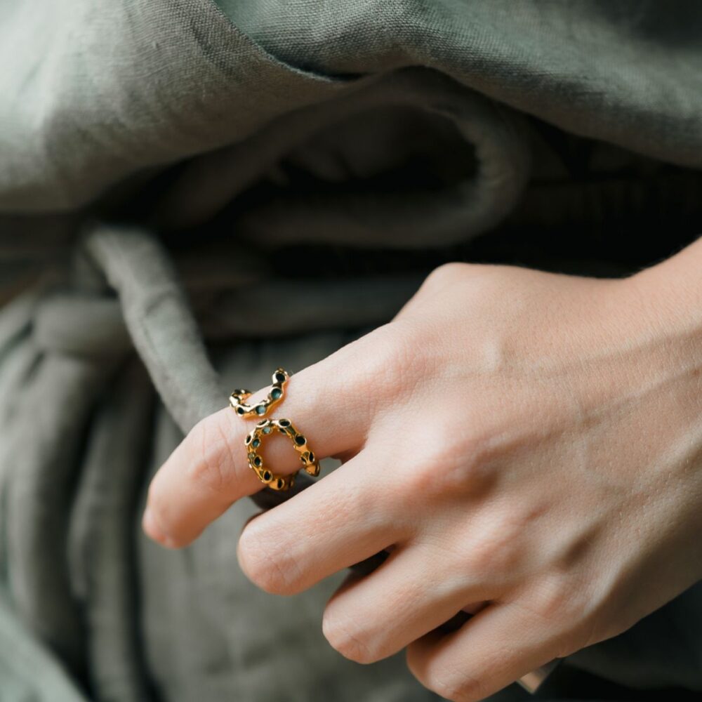 Elegant gold infinity ring adorned with black stones, perfect for stylish accessories.