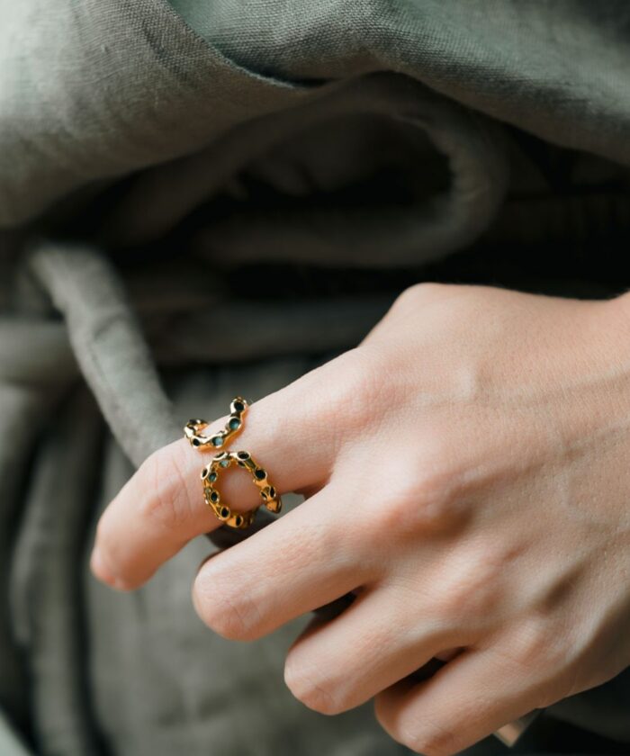 Elegant gold infinity ring adorned with black stones, perfect for stylish accessories.