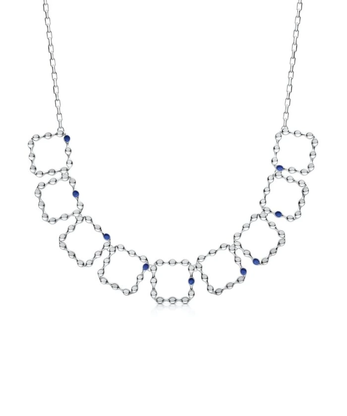 Elegant silver eternity necklace with interconnected hexagonal shapes and blue gemstone accents.