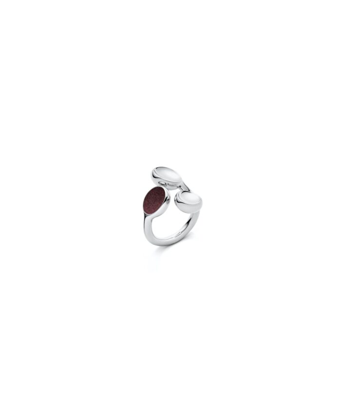 Elegant silver trilogy ring with smooth, rounded design and maroon stone accent.