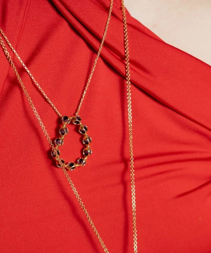 Elegant gold pendant necklace featuring purple gemstones, perfect for adding glamour to any outfit.