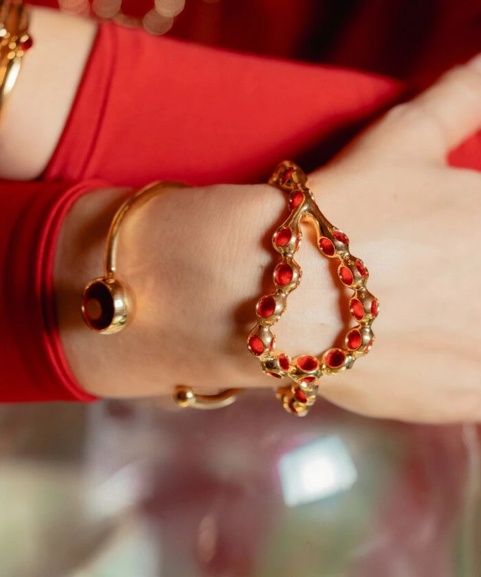 Golden cuff bracelet with red accents, stylish jewelry for women.