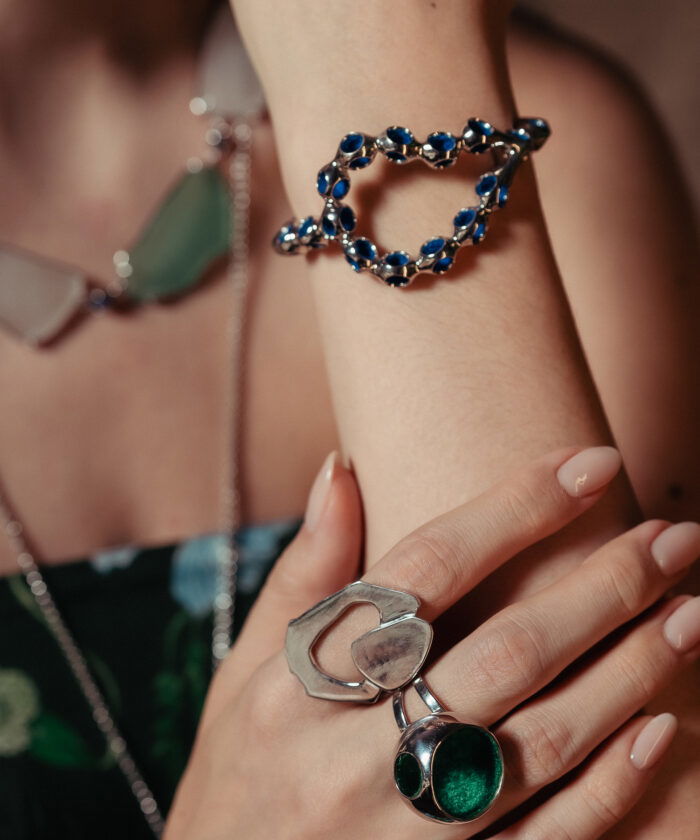 Close-up of stylish blue gemstone cuff bracelet with silver setting on model's wrist.