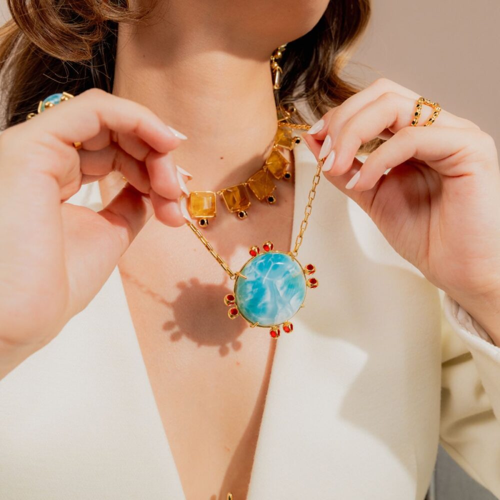 Close-up of Monica Varela necklace featuring a large turquoise pendant with red accents.