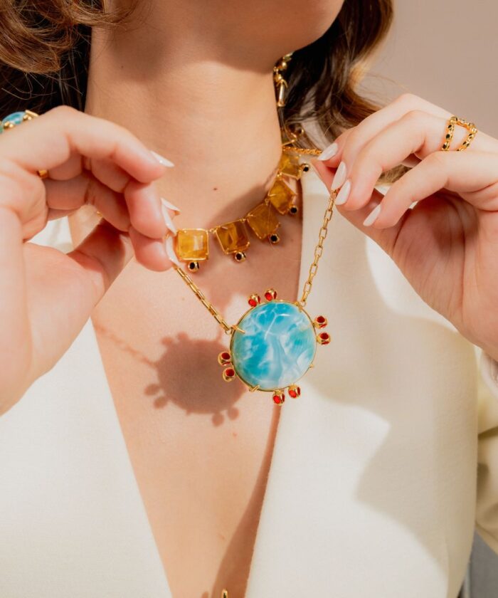 Close-up of Monica Varela necklace featuring a large turquoise pendant with red accents.