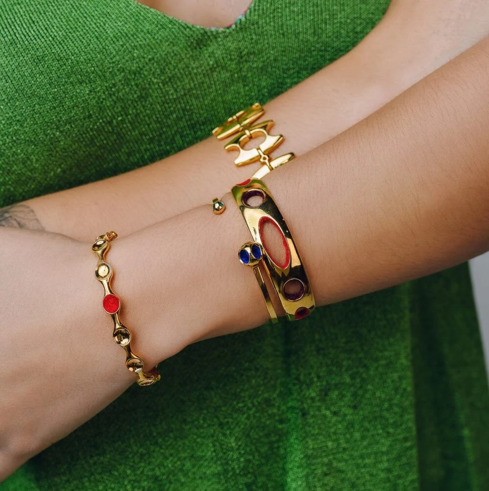 Beautiful gold jewelry with colorful accents worn on wrist, perfect for fashion and accessories.