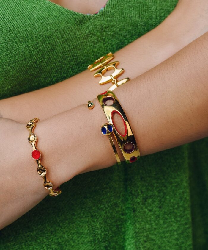 Beautiful gold jewelry with colorful accents worn on wrist, perfect for fashion and accessories.