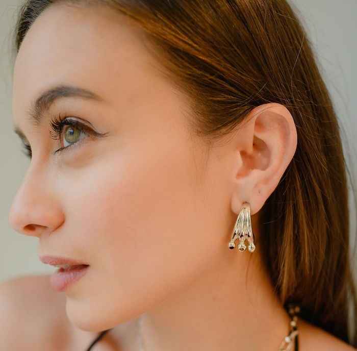 Close-up of Monica Varela showcasing elegant jewelry and flawless skin.