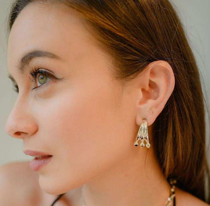 Close-up of Monica Varela showcasing elegant jewelry and flawless skin.