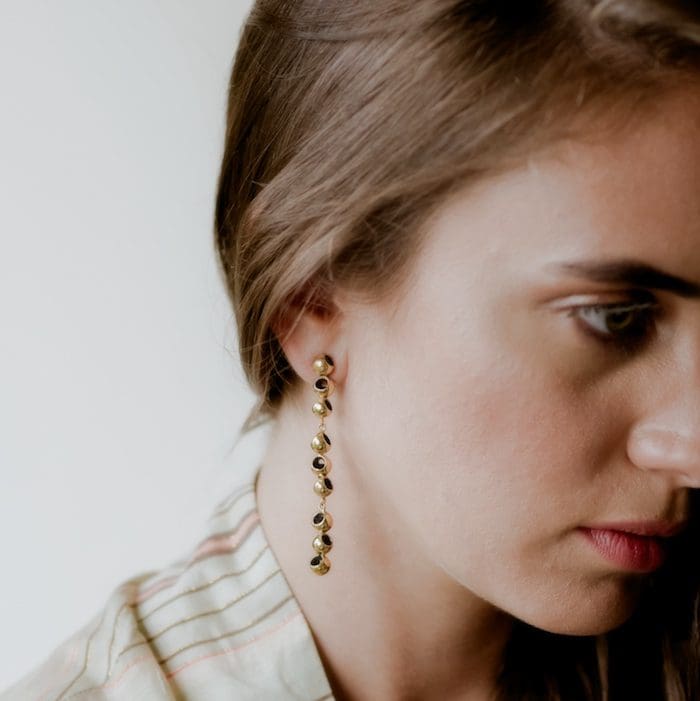 Elegant gold and black bead dangle earrings for women. Perfect for stylish outfits and special occasions.