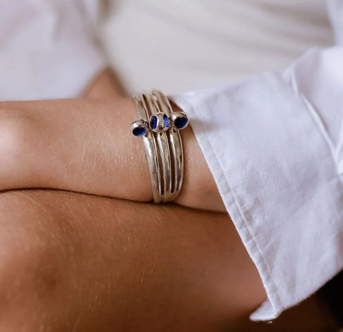 Elegant silver cuff bracelet featuring multiple blue gemstones, perfect for stylish accessories.