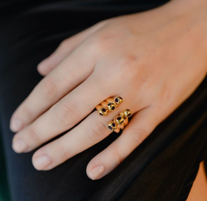 Gold skull ring with black gemstone eyes, perfect for edgy jewelry lovers, stylish and unique accessory.