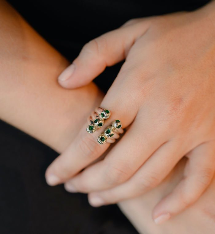 Elegant Trinity ring with green gemstone accents, perfect for stylish jewelry lovers.