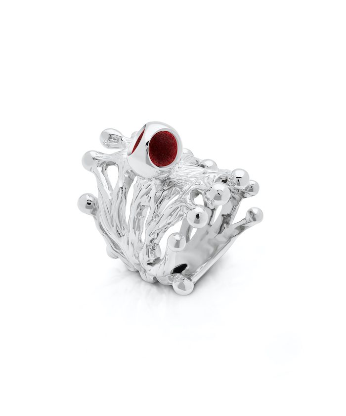 Elegant silver ring with intricate branch design and a striking red gemstone accent.