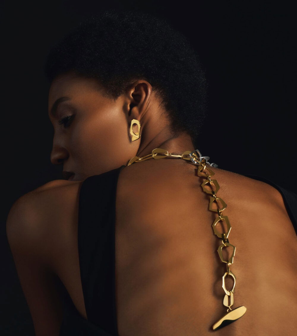 Chic gold earrings, necklace, and jewelry adorn Monica Varela for fashion photoshoot.