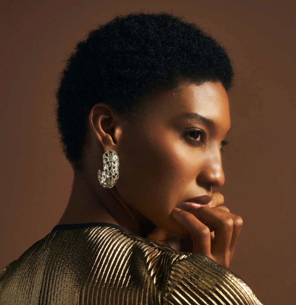 Close-up of a woman wearing intricate gold heritage earrings, highlighting luxury jewelry and sophisticated style.
