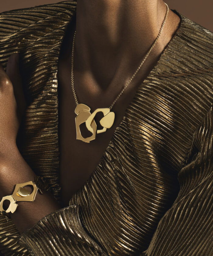 Luxurious gold jewelry set, including a statement necklace and matching bracelet with abstract geometric design.