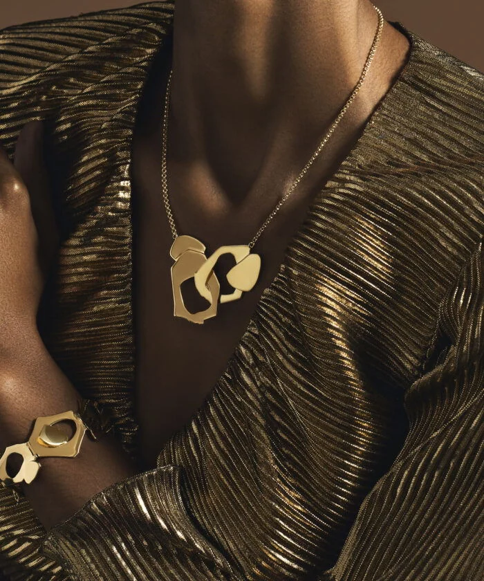 Luxurious gold jewelry set, including a statement necklace and matching bracelet with abstract geometric design.
