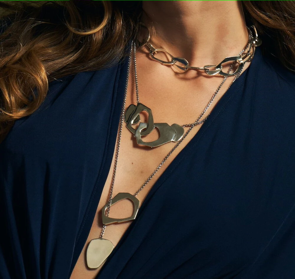 Stylish layered silver necklaces featuring geometric pendants, perfect jewelry for modern fashion lovers.