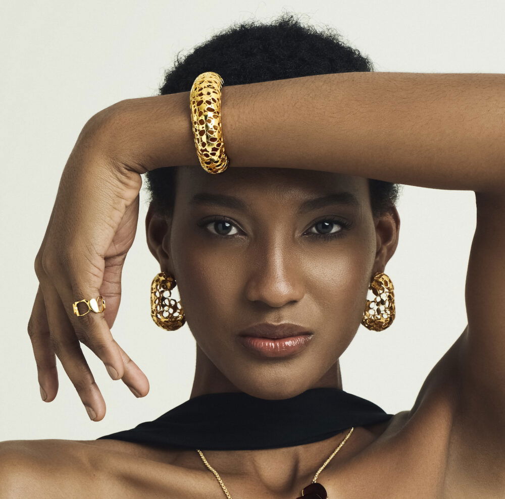 Luxury gold jewelry featuring a bold Heritage Cuff, hoop earrings, and matching accessories.