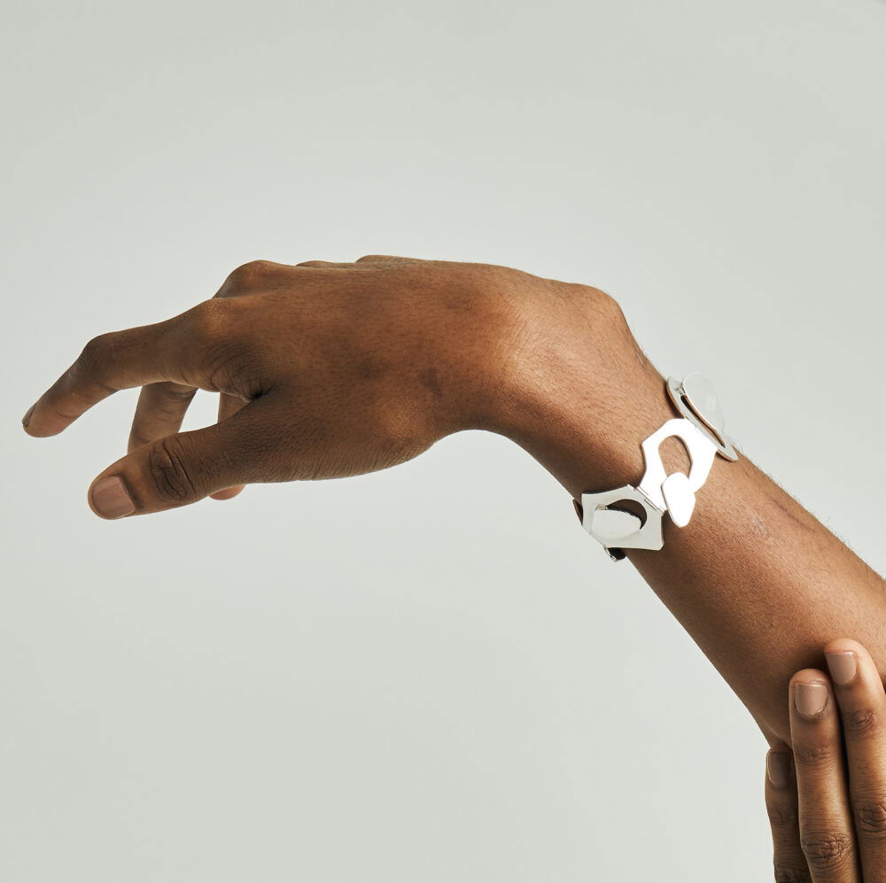 Modern silver geometric bracelet on a woman's wrist, stylish jewelry accessory.