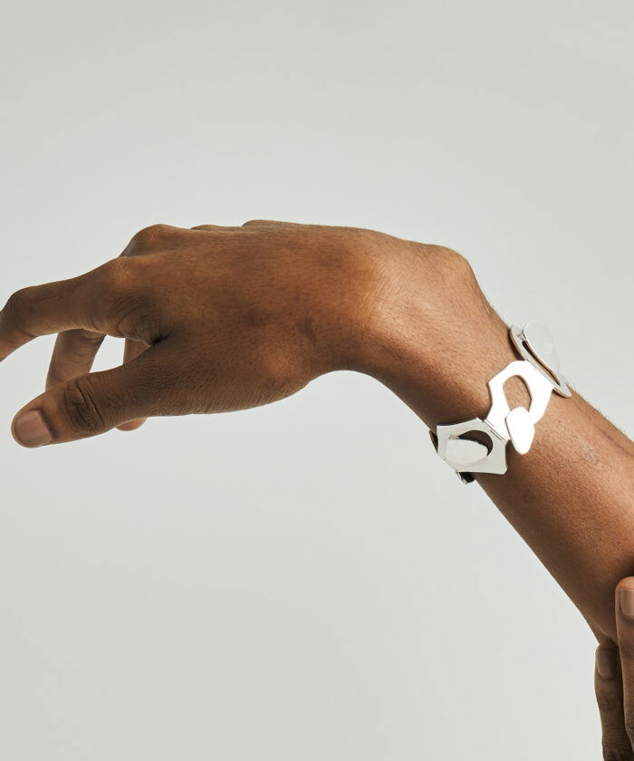 Modern silver geometric bracelet on a woman's wrist, stylish jewelry accessory.