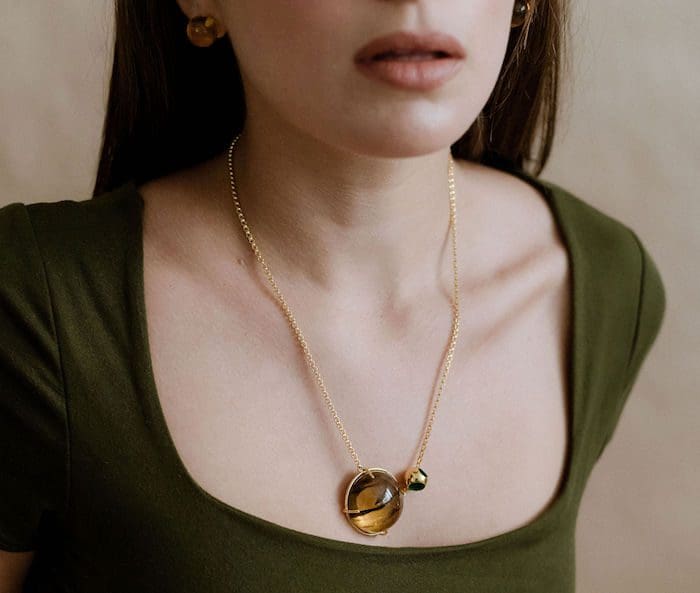Amber necklace featuring a small circular amber pendant and delicate gold chain, perfect for everyday style.