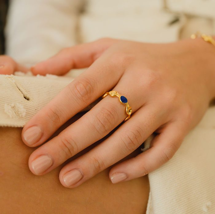 Elegant gold ring with blue gemstone detail.