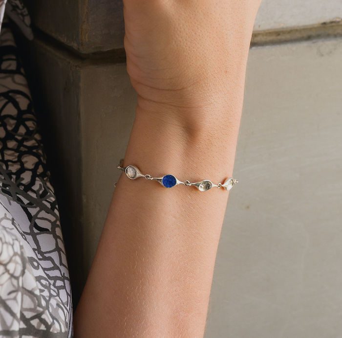 Elegant stem bracelet with silver and blue gemstone accents.