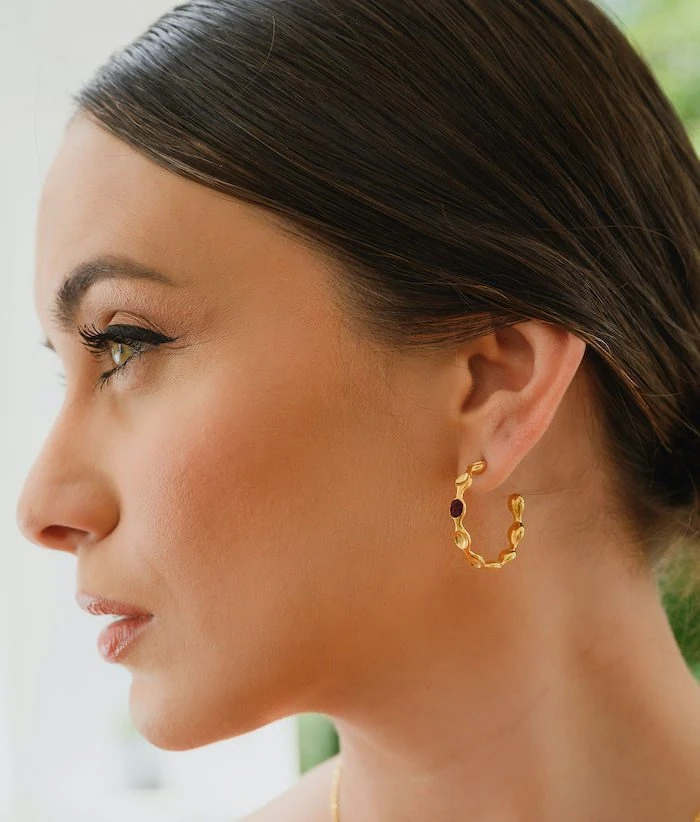 Elegant gold hoop earrings with black accents, perfect for stylish accessories.