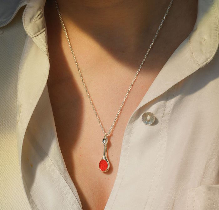 Elegant silver bud pendant necklace with red accents, perfect for stylish accessories.