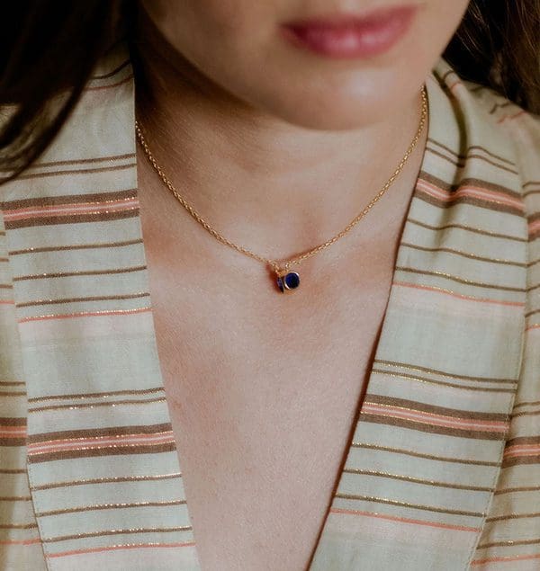 Elegant gold necklace with a blue gemstone pendant, perfect for any occasion.