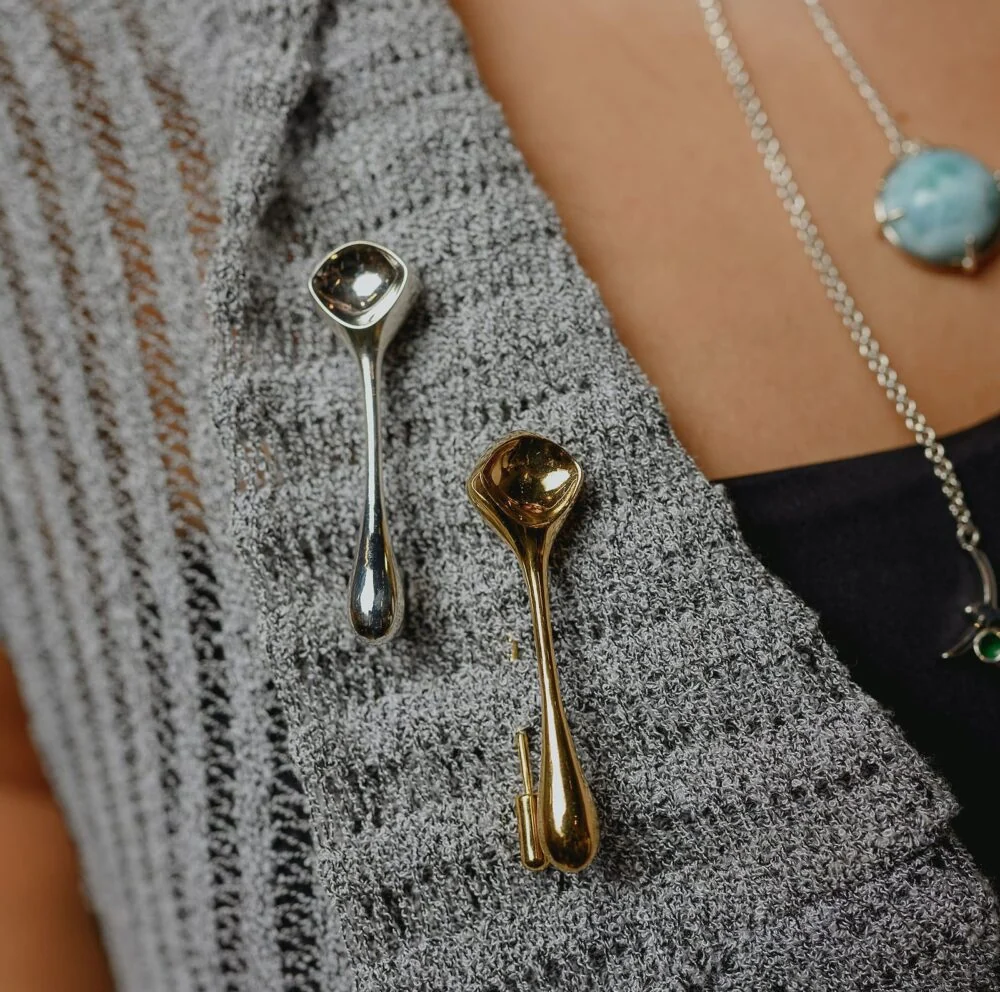 Close-up of elegant silver and gold jewelry pieces on textured clothing.
