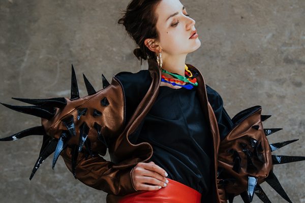 Stylish Monica Varela in bold fashion outfit with spiked leather sleeves.