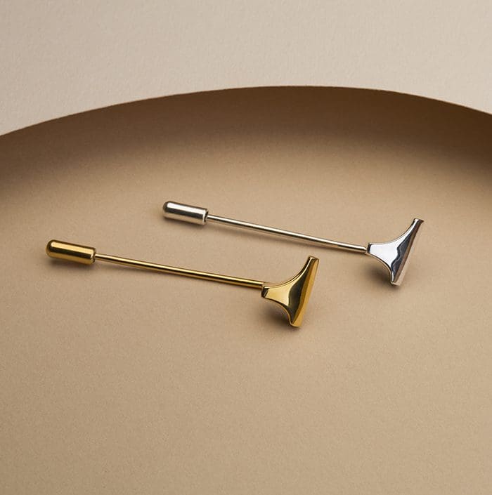 Stylish silver and gold T-shaped lapel pins, perfect for fashion accessories or modern decor.