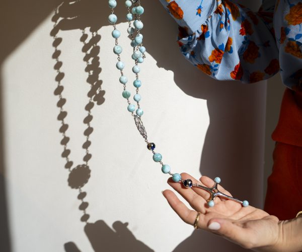 Larimar rosary held in hands against the light