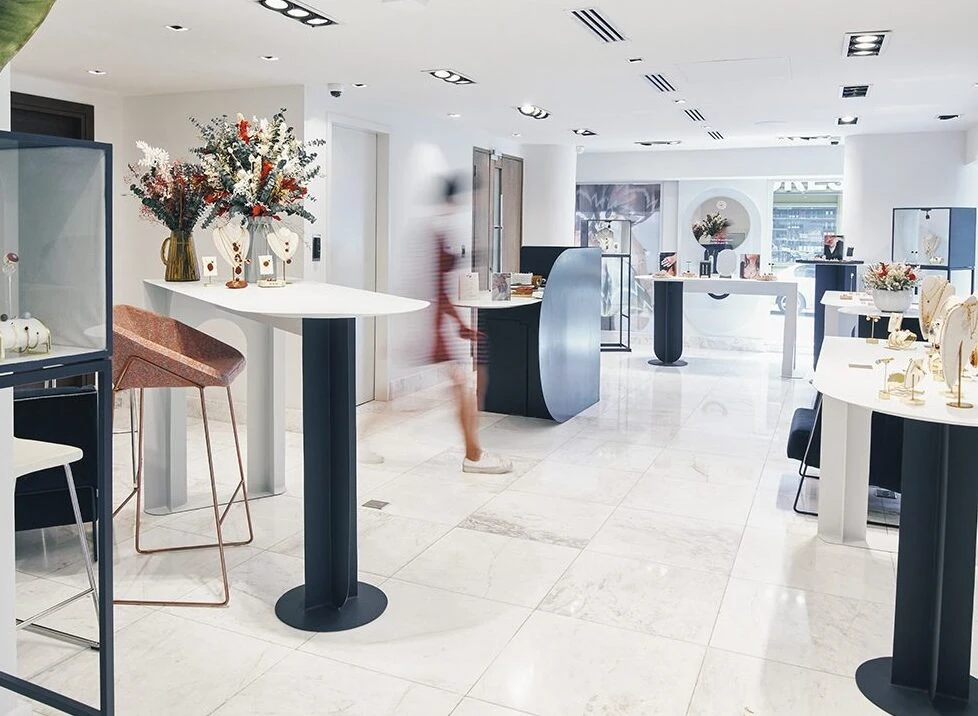 Beautiful jewelry store with contemporary decor, display tables, and floral arrangements for retail shopping.