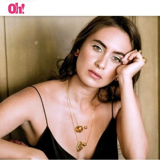 Elegant Monica Varela with stylish makeup, jewelry, and black dress.